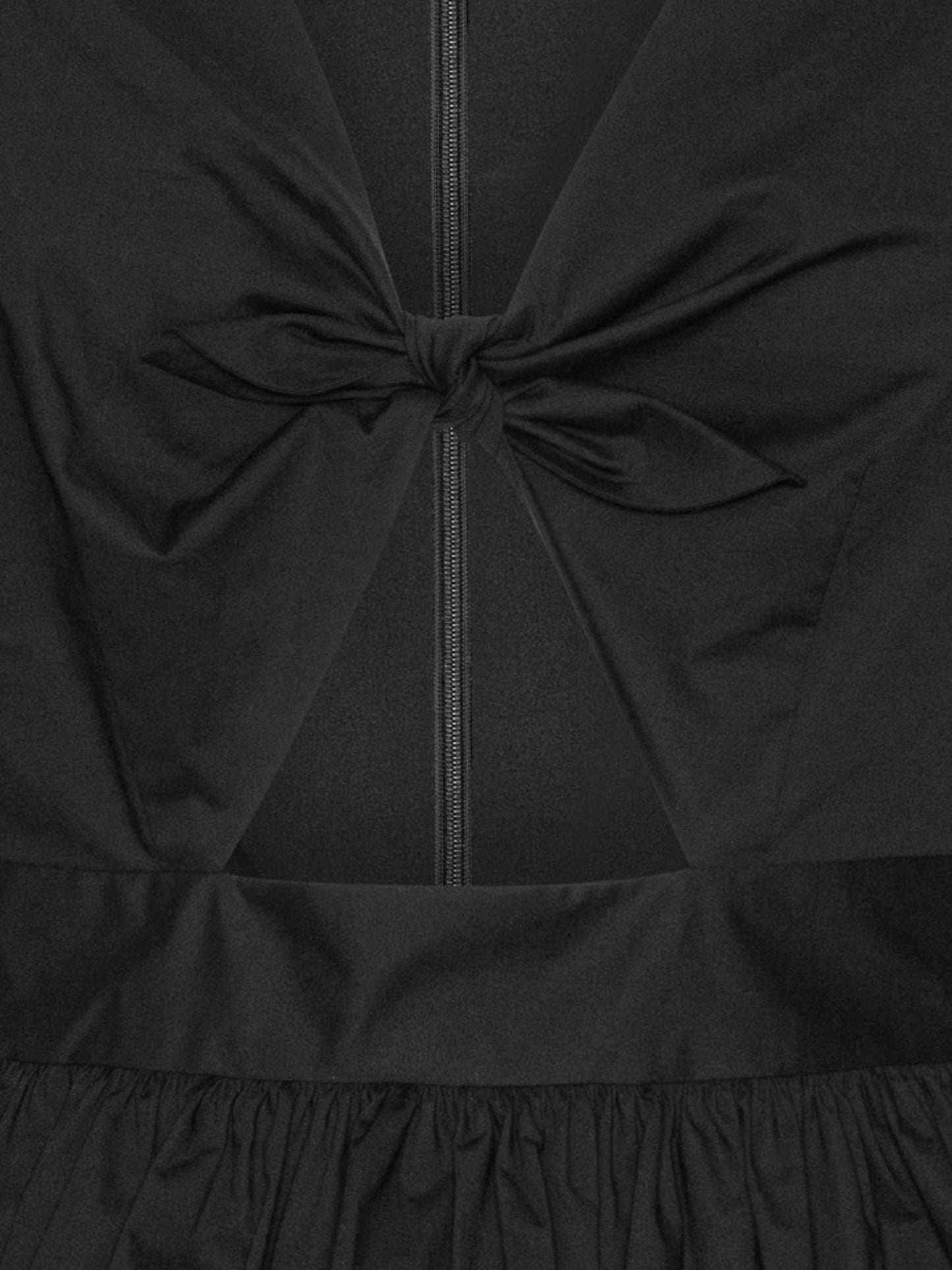 détail noeud sur un top avec des manches bouffantes noires