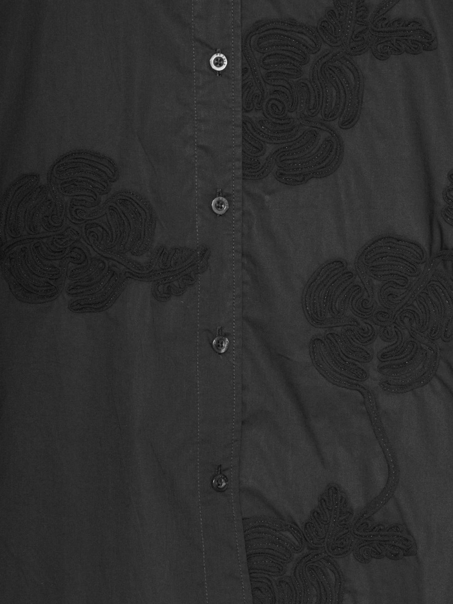 détail des broderies en fleur d'une chemise oversize noires