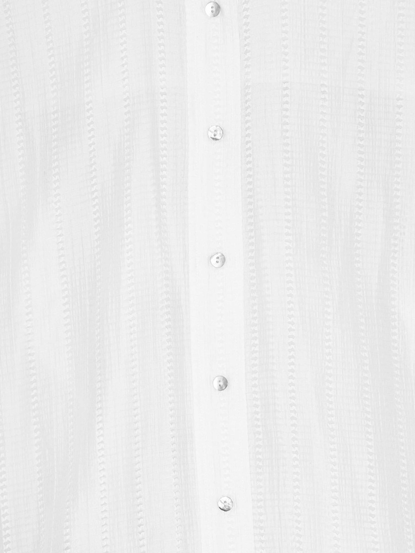 détail boutons sur une chemise blanche ajourée